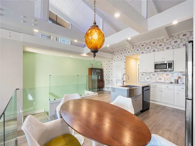 a view of a kitchen with kitchen island a sink stainless steel appliances and cabinets