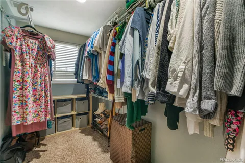 a view of walk in closet with clothes and shoes