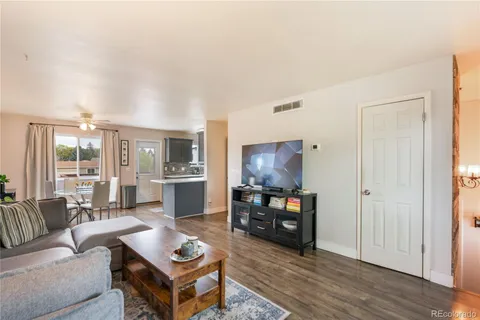 a living room with furniture a flat screen tv and a table