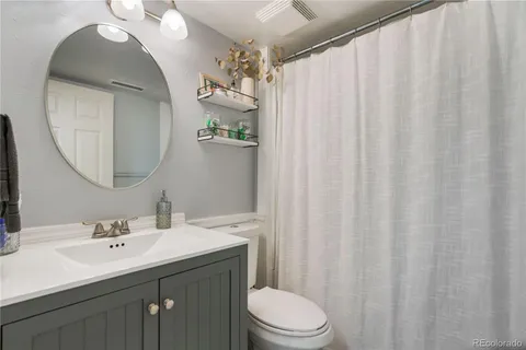 a bathroom with a sink vanity mirror and toilet