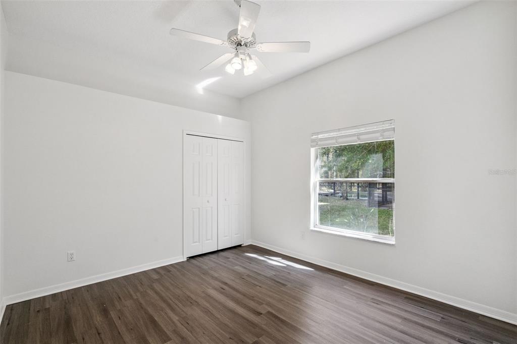 2541 Teton Stone Run Orlando, FL 32828 - Photo 43 of 82 an empty room with wooden floor chandelier fan and windows