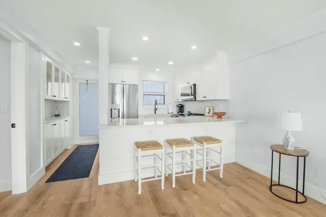 a kitchen with stainless steel appliances granite countertop a table chairs stove a sink and a refrigerator