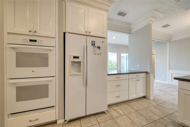 a kitchen with stainless steel appliances white cabinets and white appliances