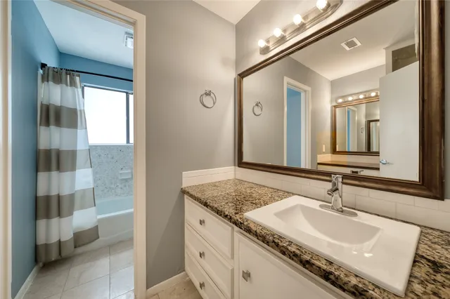 a bathroom with a granite countertop sink and a mirror