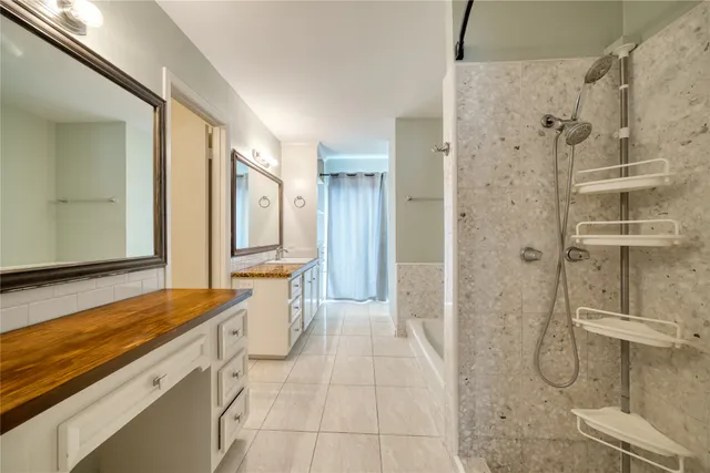 a spacious bathroom with a granite countertop double vanity sink and a mirror