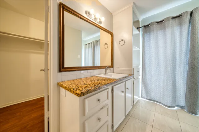 a bathroom with a granite countertop sink and a mirror
