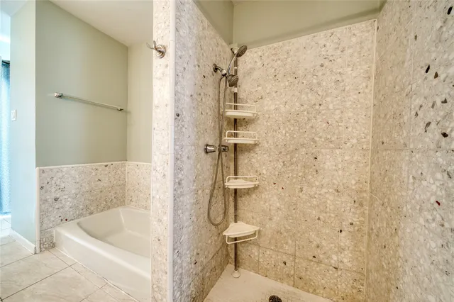 a bathroom with a tub a toilet and a shower