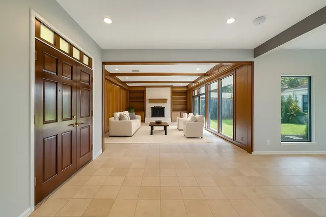 a living room with furniture a large window and a flat screen tv