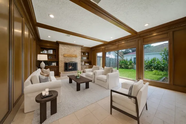 a living room with fireplace furniture and a large window