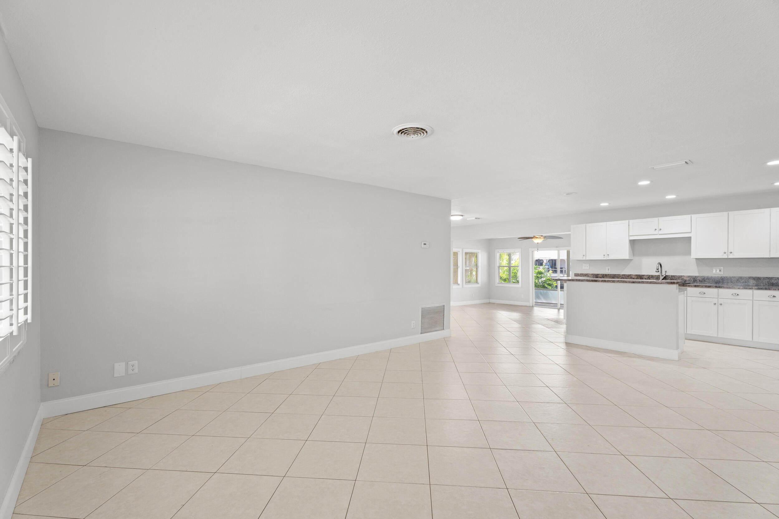 1459 Southwest Seahawk Way Palm City, FL 34990 - Photo 5 of 43 a view of an empty room and kitchen with granite countertop a sink