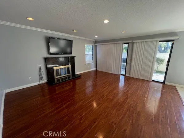 a view of a livingroom with wooden floor and a flat screen tv