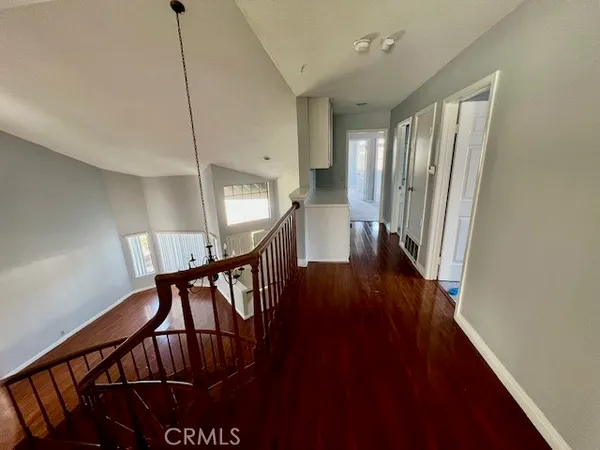 a view of a hallway with wooden floor and stairs