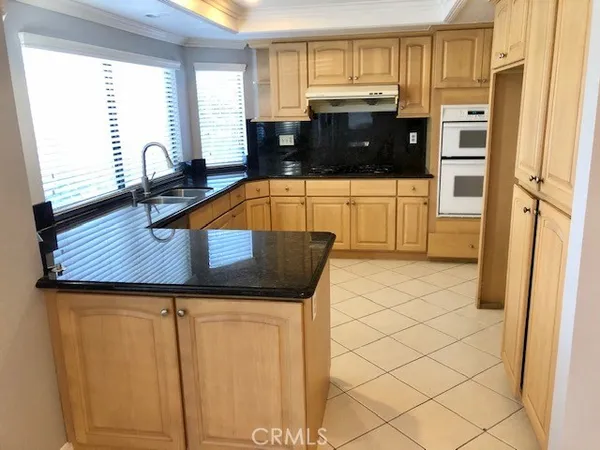 a kitchen with stainless steel appliances a stove a microwave a sink and cabinets