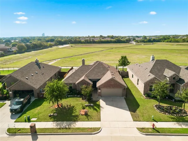 an aerial view of residential houses with outdoor space and ocean view