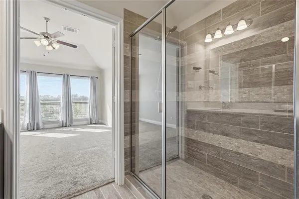 a bathroom with a double vanity sink mirror and shower