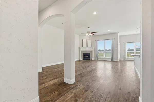 a view of empty room with wooden floor and fireplace