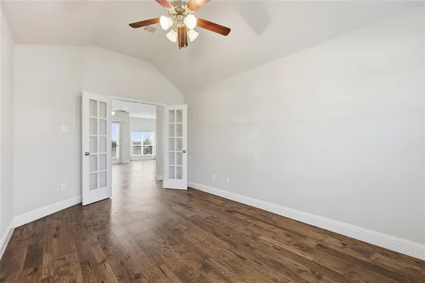 a view of an empty room with wooden floor