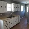 a kitchen with stainless steel appliances granite countertop white cabinets and window