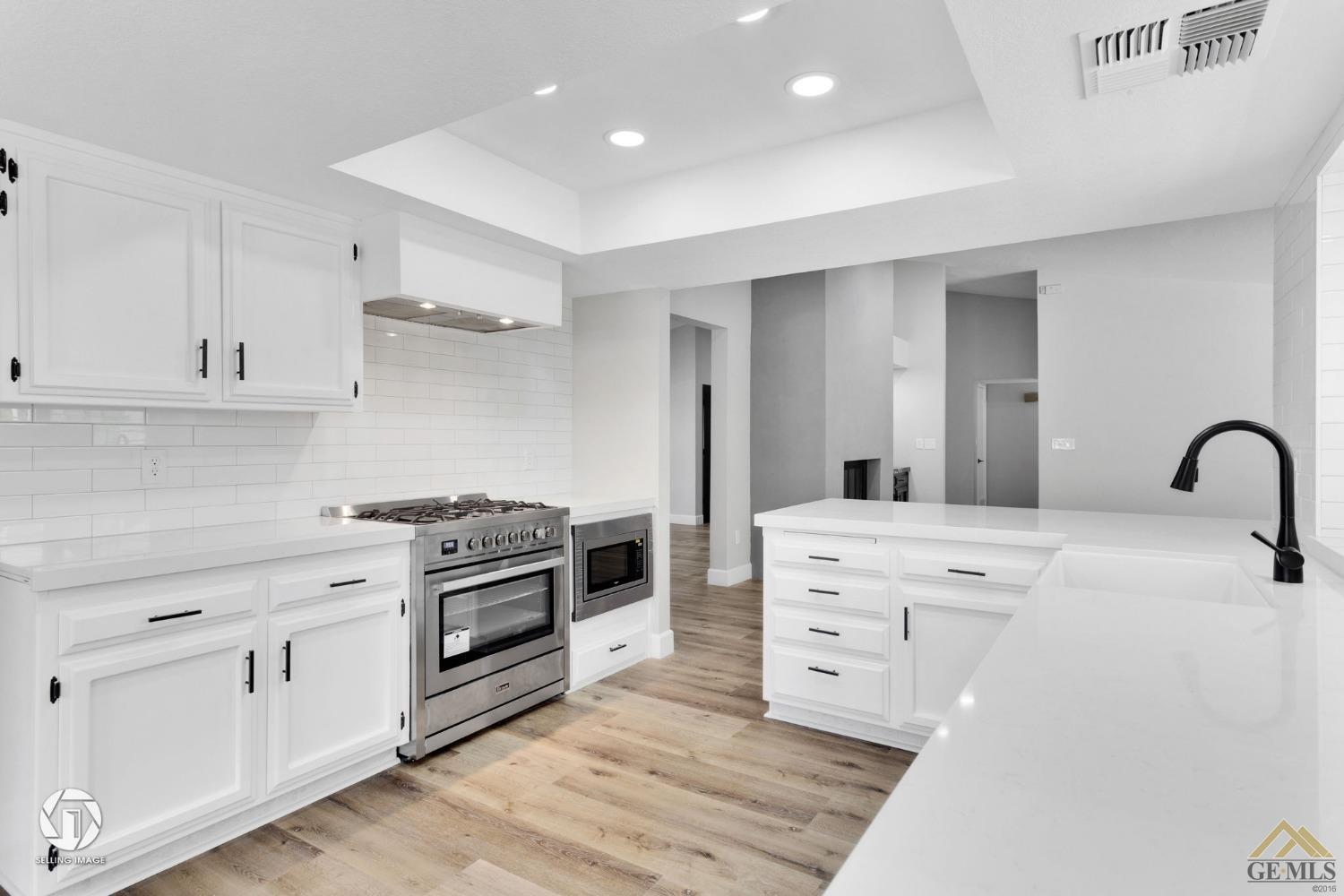 Undisclosed Address Bakersfield, CA 93308 - Photo 27 of 48 a kitchen with white cabinets and appliances
