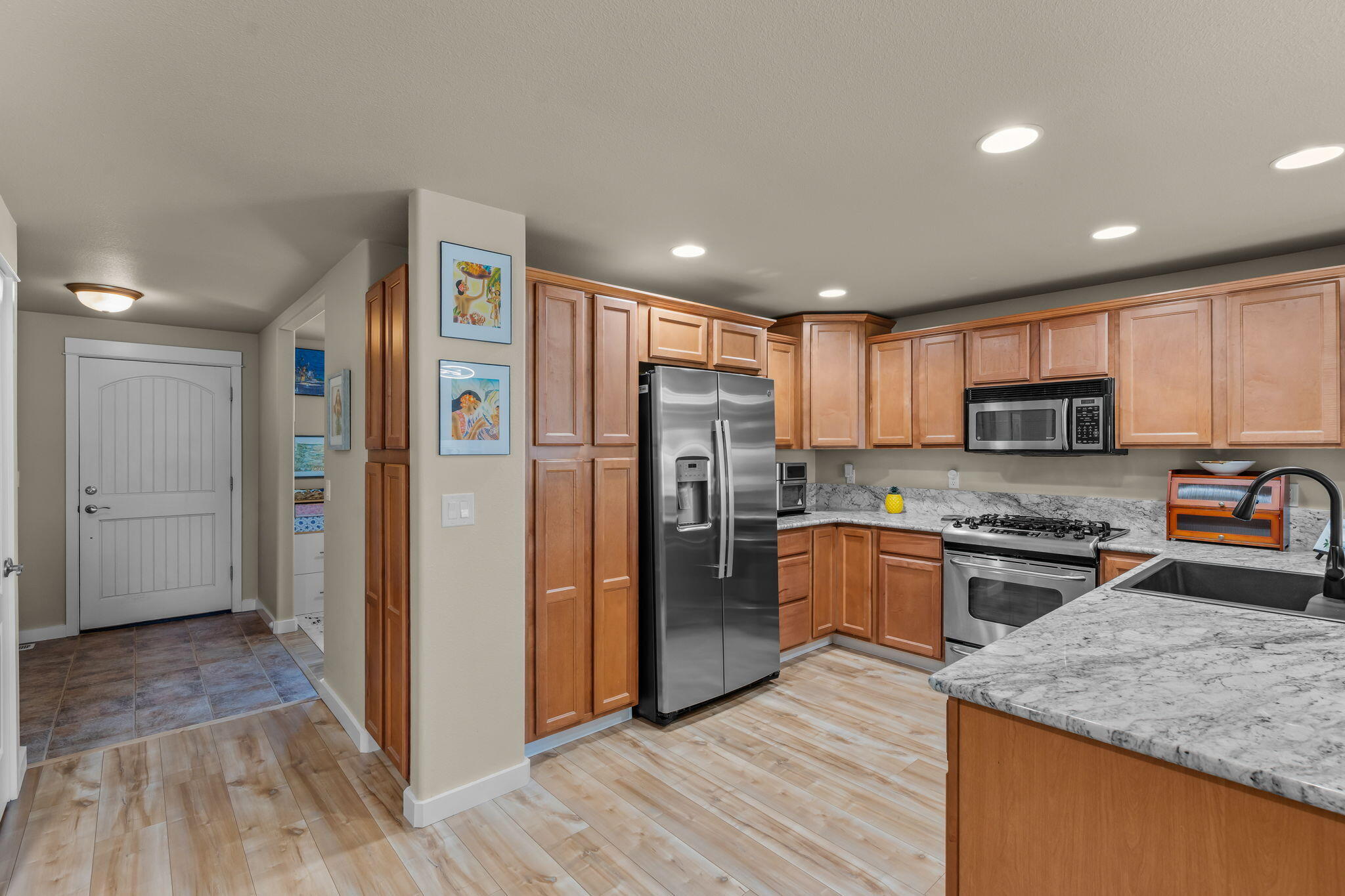 3714 Southwest 29th Street Redmond, OR 97756 - Photo 5 of 21 a kitchen with stainless steel appliances granite countertop a refrigerator a stove top oven a sink and dishwasher with wooden floor