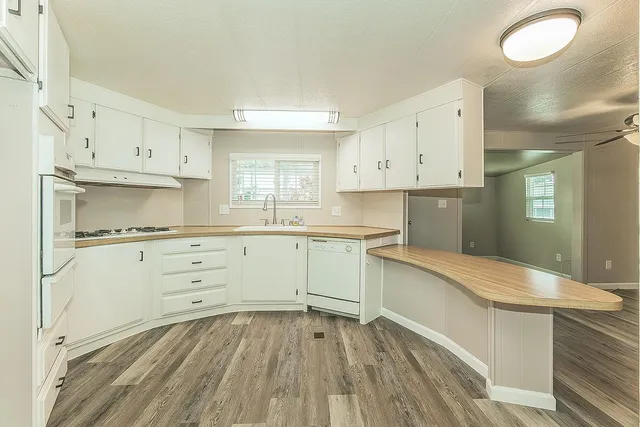 a kitchen with granite countertop white cabinets and white appliances