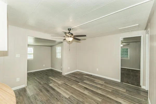 a view of a kitchen with wooden floor and a ceiling fan