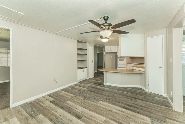 a kitchen with a refrigerator and white cabinets