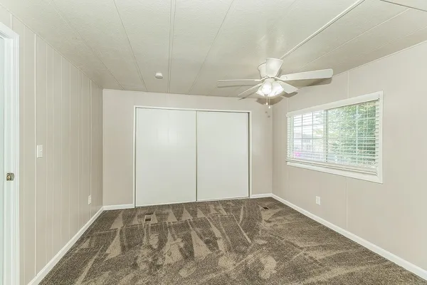 an empty room with fan and windows