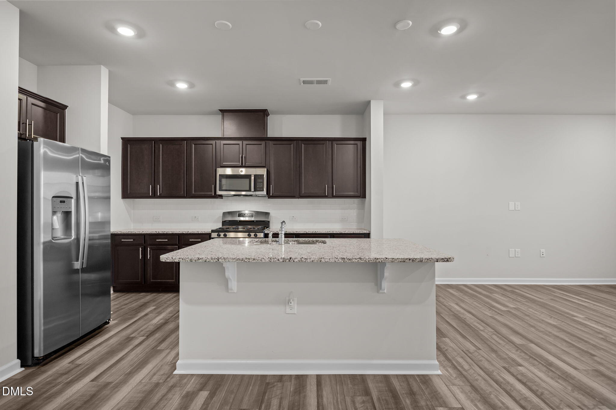 5016 Kota Street Raleigh, NC 27610 - Photo 22 of 37 a large kitchen with stainless steel appliances a refrigerator a sink a stove a microwave and cabinets