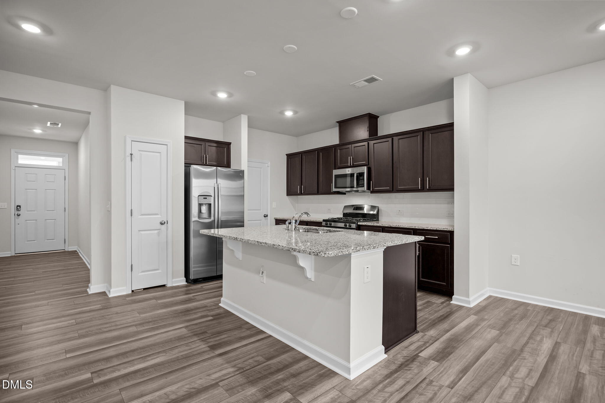 5016 Kota Street Raleigh, NC 27610 - Photo 23 of 37 a kitchen with stainless steel appliances granite countertop a refrigerator stove a sink and a oven with wooden floor