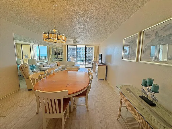 a dining room with furniture a chandelier and wooden floor