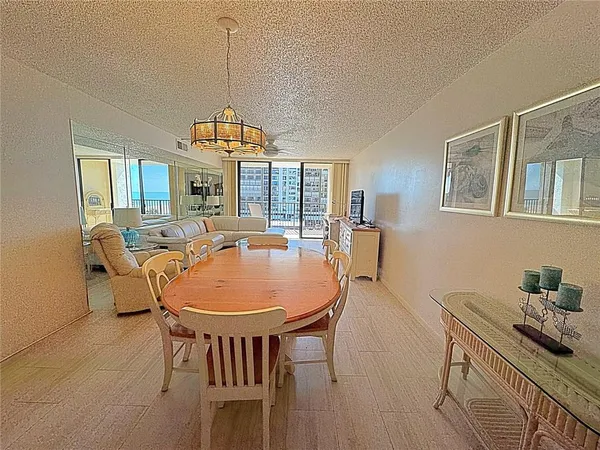 a dining room with furniture a chandelier and wooden floor