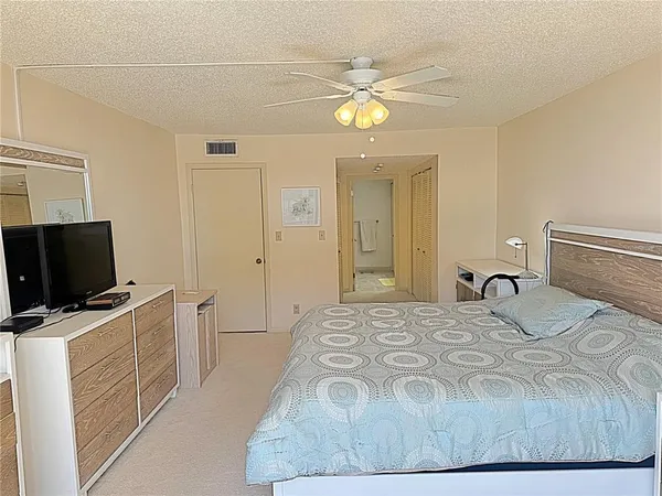 a bedroom with a bed and a flat tv screen on the dresser