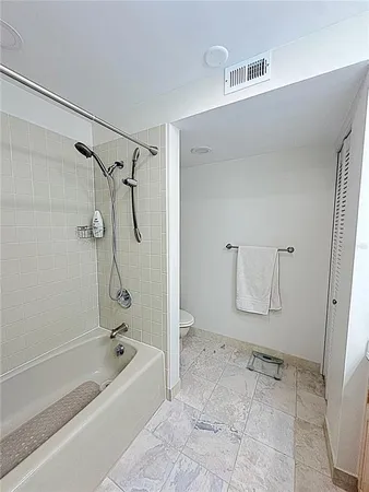 a bathroom with a granite countertop bathtub shower and sink