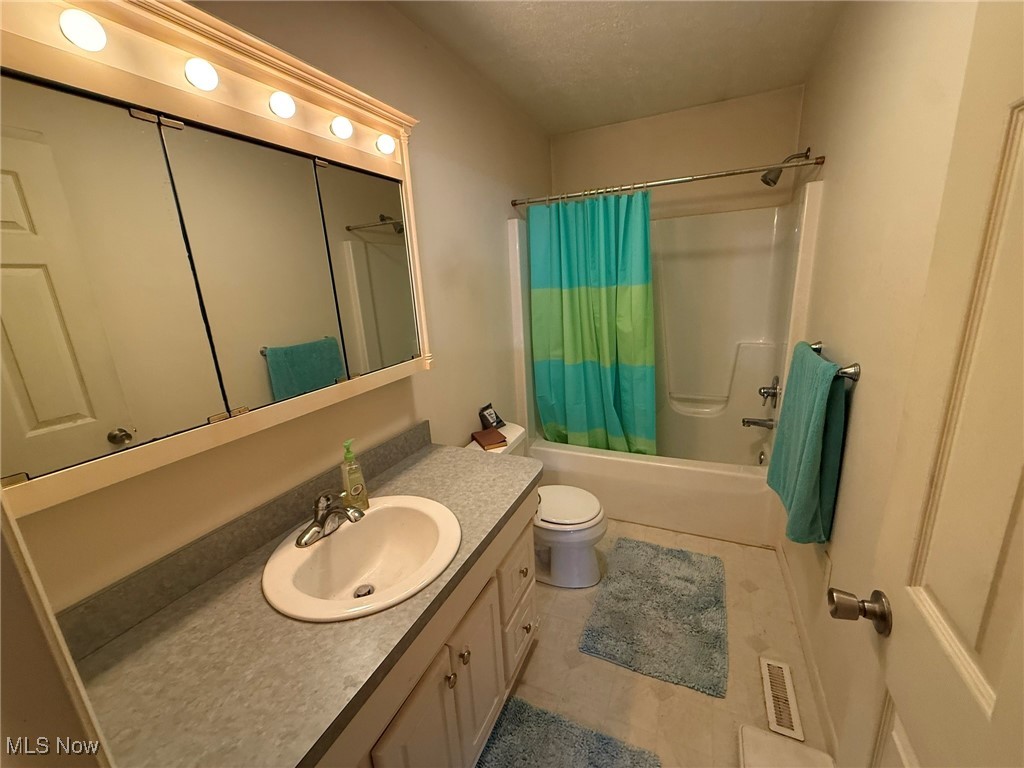 6920 Riverside Road Southeast Gnadenhutten, OH 44629 - Photo 12 of 41 Bathroom with vanity, shower / tub combo, toilet, and tile patterned flooring