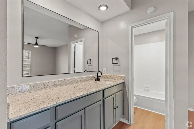 a bathroom with a granite countertop sink and a mirror