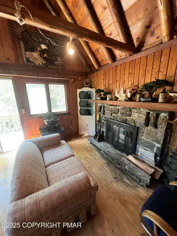 a living room with furniture a flat screen tv and a large window