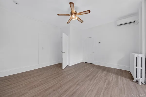 a view of room with hardwood floor and a ceiling fan