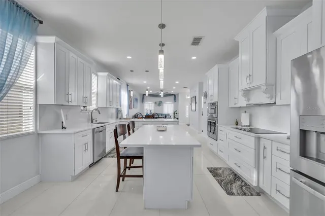 a kitchen with a table chairs refrigerator and cabinets