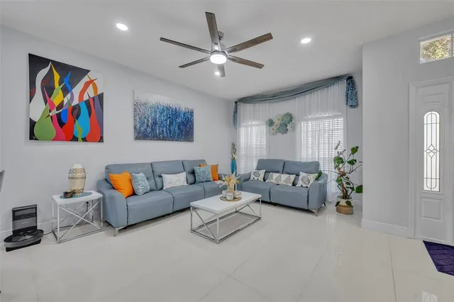 a living room with furniture ceiling fan and a rug