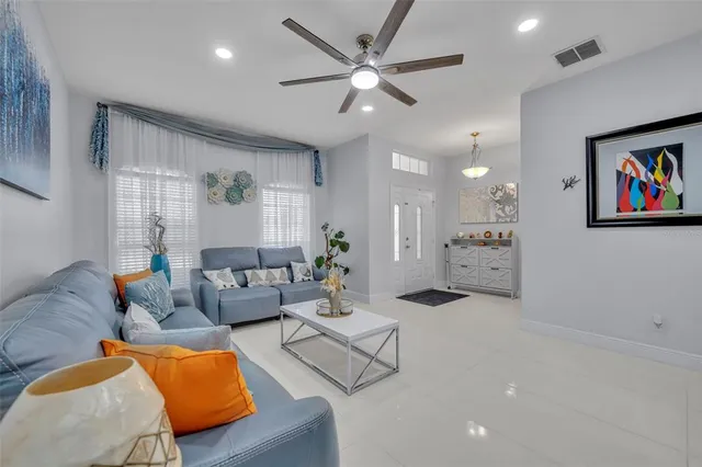 a living room with furniture kitchen view and a chandelier