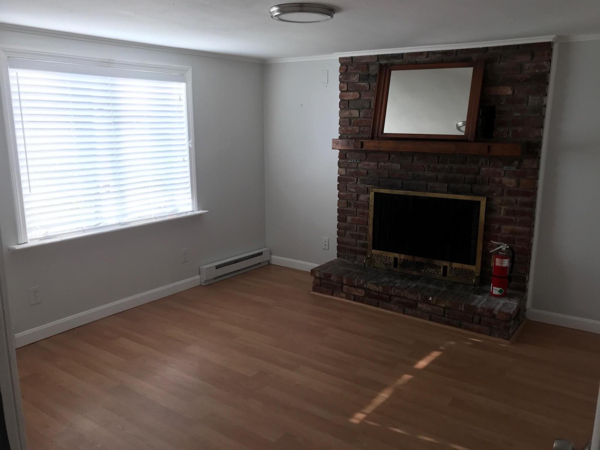 104 High School Road Hyannis, MA 02601 - Photo 5 of 14 a living room with a fireplace and a flat screen tv