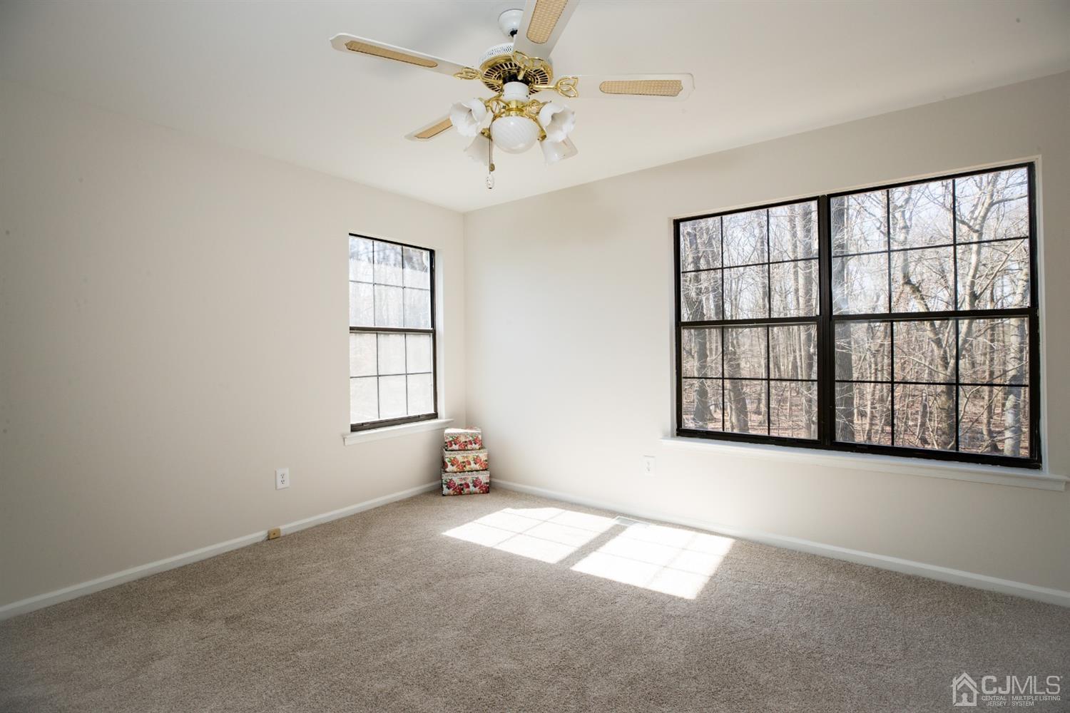 1601 Timber Oaks Road Edison, NJ 08820 - Photo 21 of 29 an empty room with windows and ceiling fan
