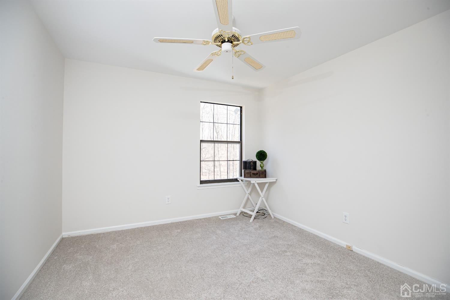 1601 Timber Oaks Road Edison, NJ 08820 - Photo 22 of 29 an empty room with a window and a fan