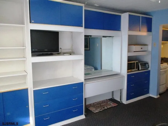 a bedroom with a bed and a view of kitchen