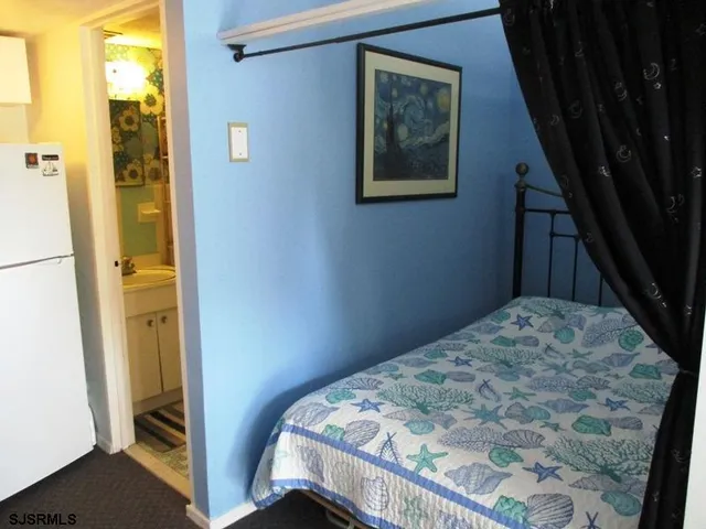 a living room with furniture and a refrigerator