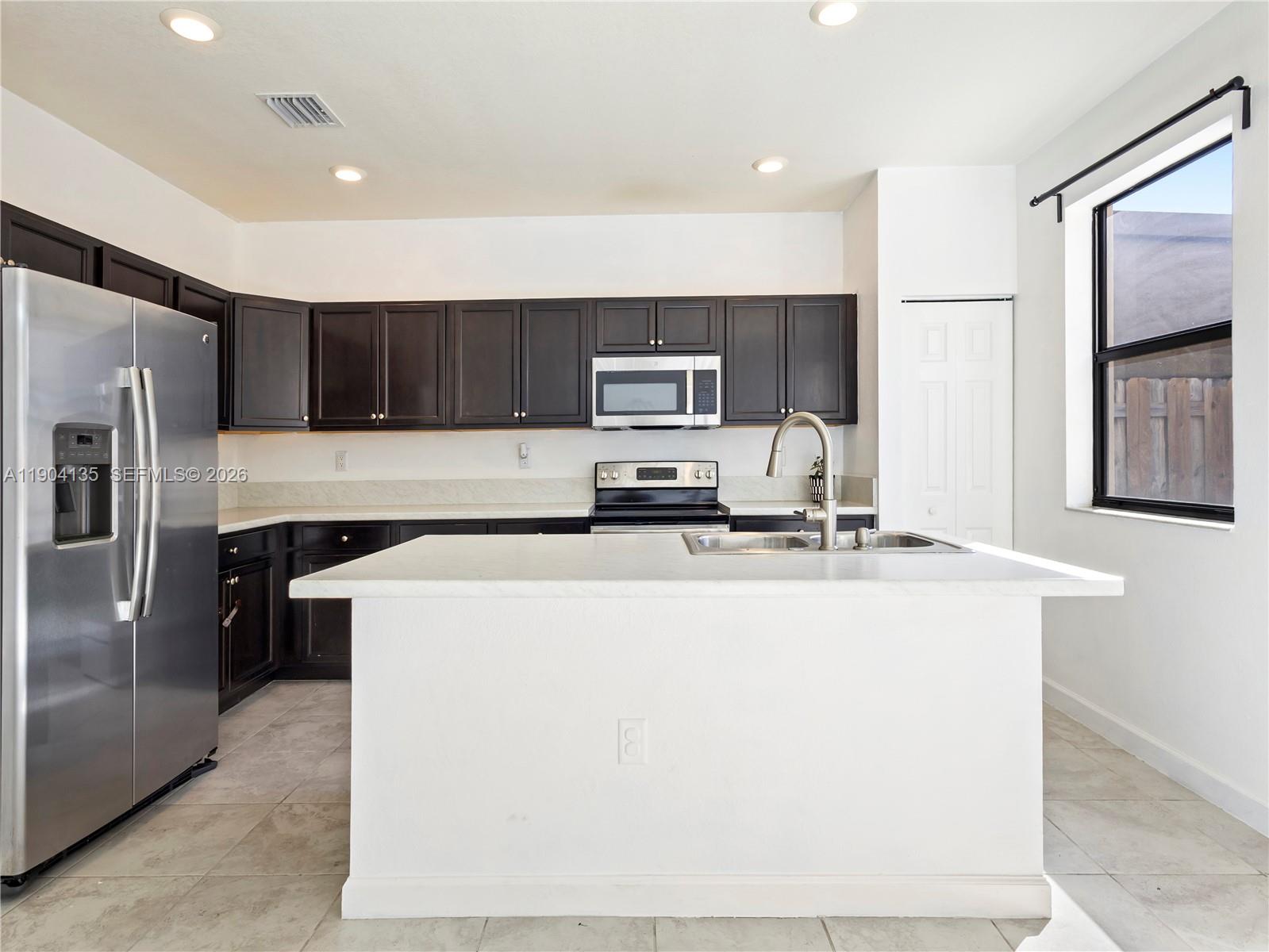 11410 Southwest 252nd Terrace Homestead, FL 33032 - Photo 15 of 38 a kitchen with stainless steel appliances a refrigerator sink and stove