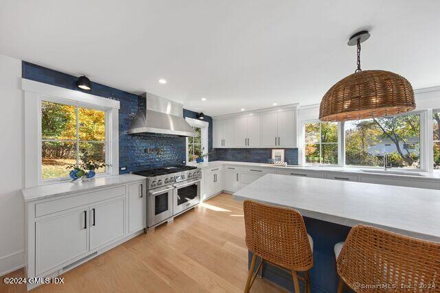 77 Stanton Road Darien, CT 06820 - Photo 13 of 39 a kitchen with a stove a sink a microwave a dining table and chairs
