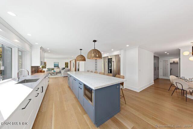 77 Stanton Road Darien, CT 06820 - Photo 10 of 39 a large kitchen with stainless steel appliances a stove a sink dishwasher and a dining table with wooden floor