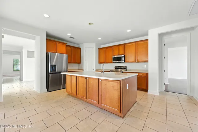 a kitchen with stainless steel appliances granite countertop a sink a stove and a refrigerator